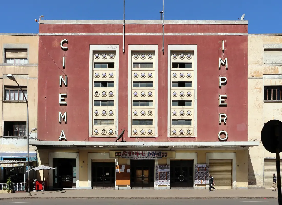 The red facade of Cinema Impero in Asmara, with the word Cinema spelled down one side