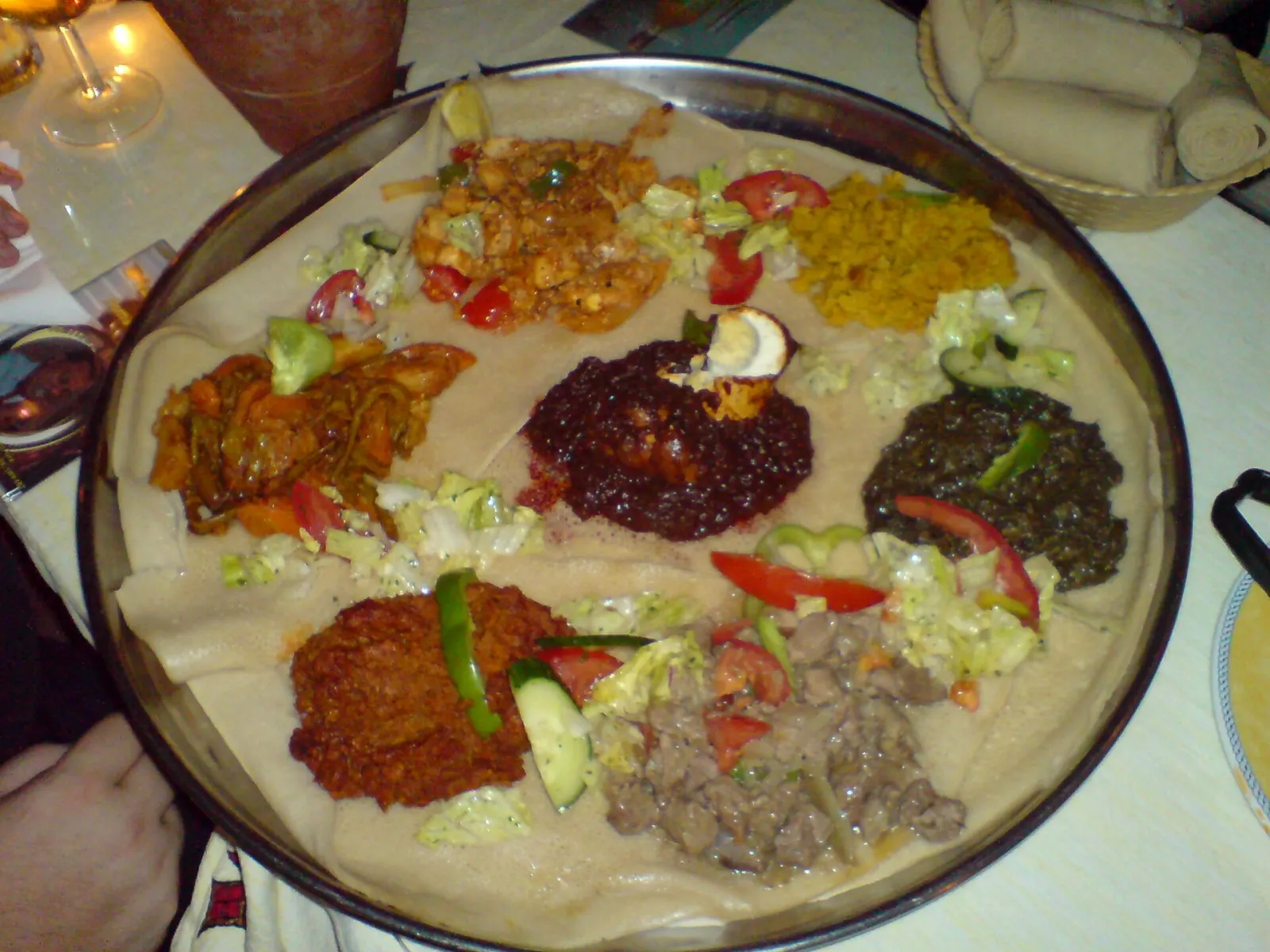 Eritrean stews and vegetables spooned onto a large round of injera