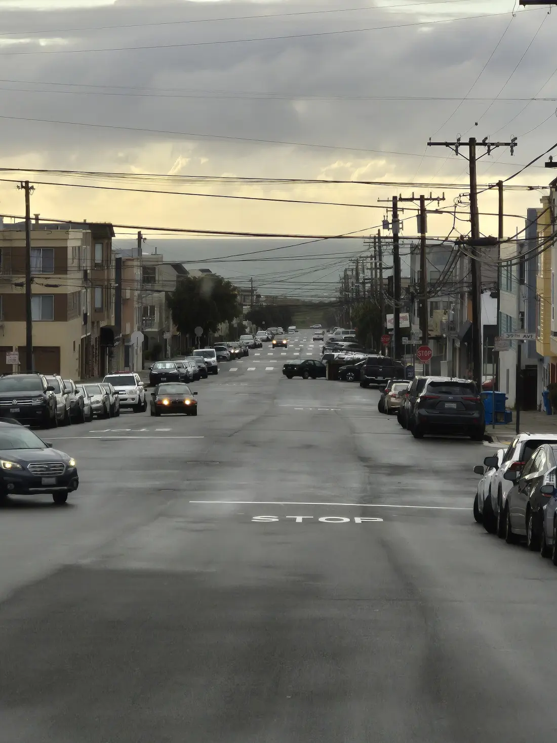 Irving Street in the Sunset District, lined with parked cars and power lines